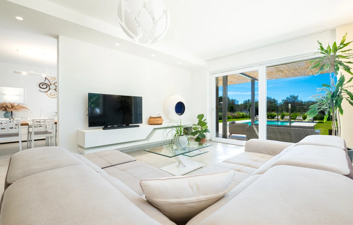 Living room with glass doors overlooking the terrace and pool